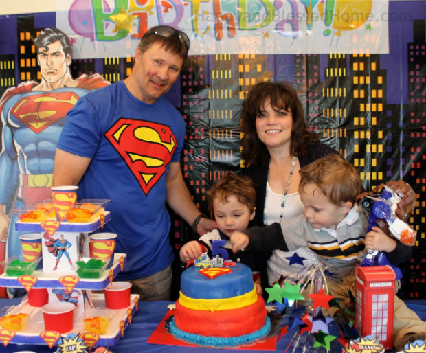 Blowing out the candles on his 5 Year Old Superman Birthday Party Cake HappyandBlessedHome